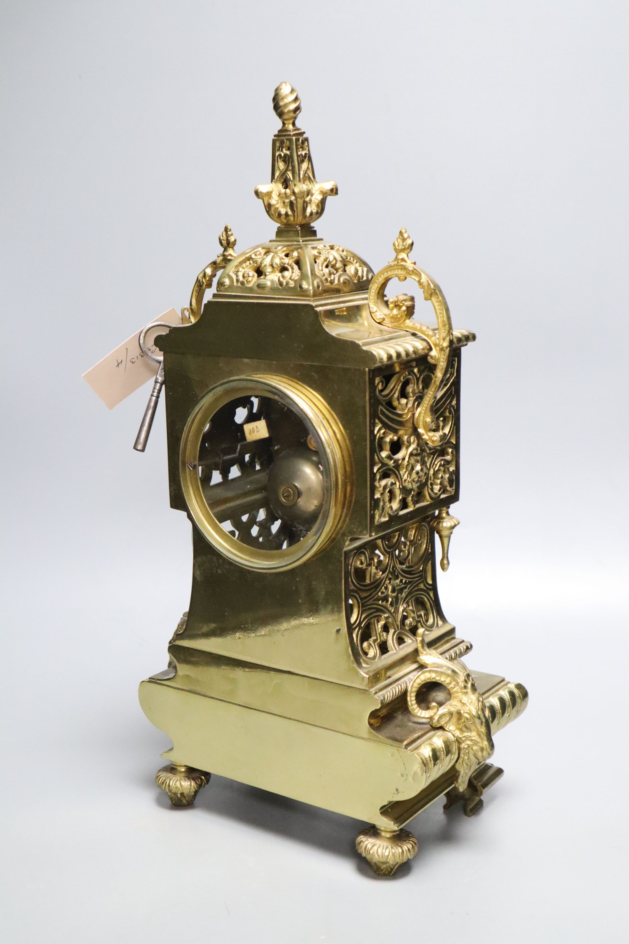 A French brass rococo-style mantel clock, with key and pendulum